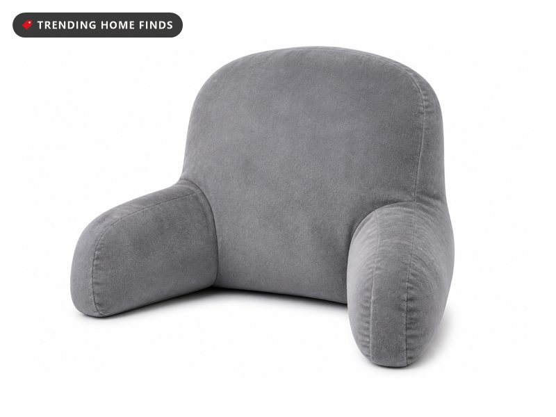 A plush gray reading pillow with a tall rounded back and two padded arms in soft velvety fabric.