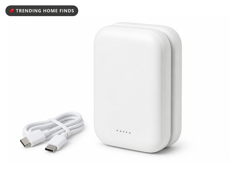 Two rounded white rechargeable hand warmers joined back to back by magnets, a short cable beside them.
