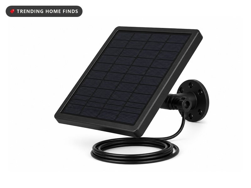 A small dark solar panel in a black frame on an adjustable wall bracket with a black charging cable.