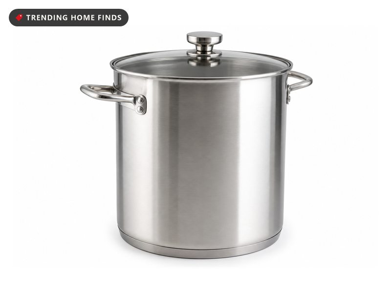 A tall brushed stainless steel stock pot with two riveted side handles and a clear tempered glass lid.