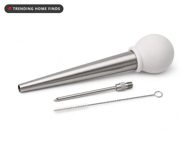 A stainless steel turkey baster with a white silicone bulb, a screw on needle and a wire cleaning brush.