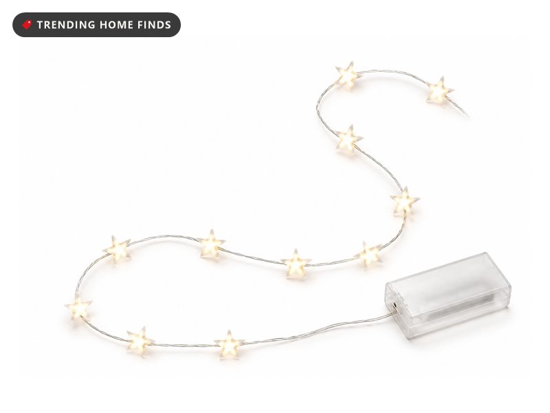 A strand of small warm white star shaped lights on a thin silver wire with a small battery box.