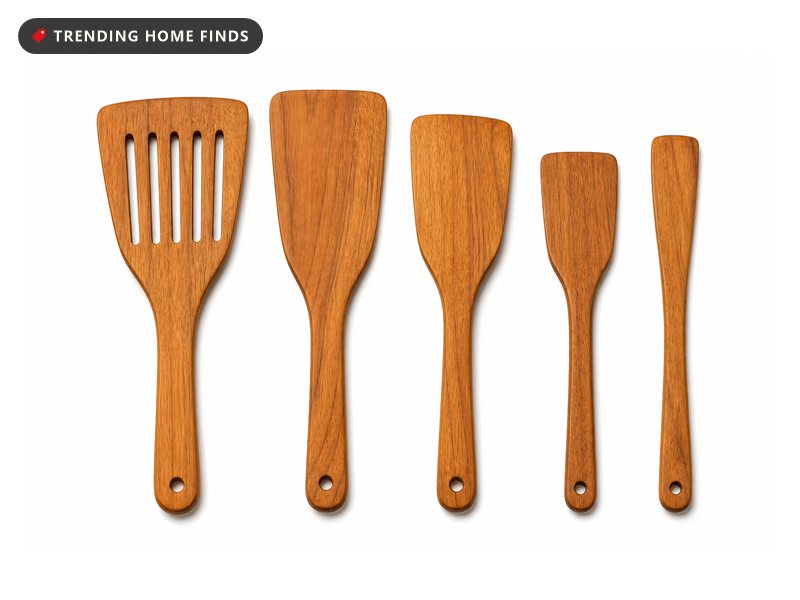 Five flat teak spurtles lying side by side, one wide with a row of slots.