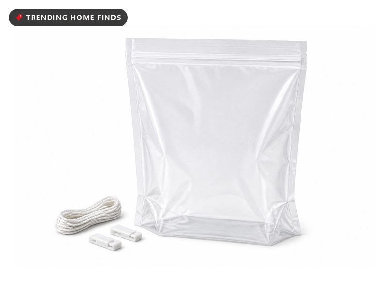A clear heavy duty brining bag standing upright with its double zipper closed, cotton string and two clips beside it.