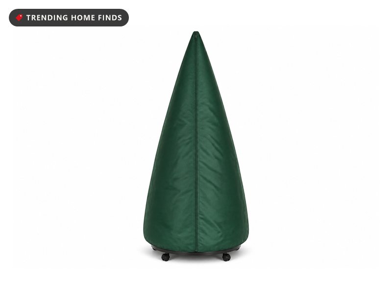 A tall green upright tree storage bag zipped closed, standing on a round low rolling stand.