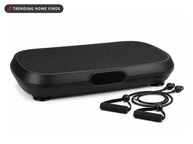 A slim black vibration plate with a ridged top and a small front control panel, two resistance bands beside it.