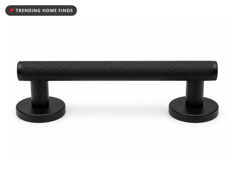 A short matte black knurled brass shower foot rest bar on two round mounting flanges.