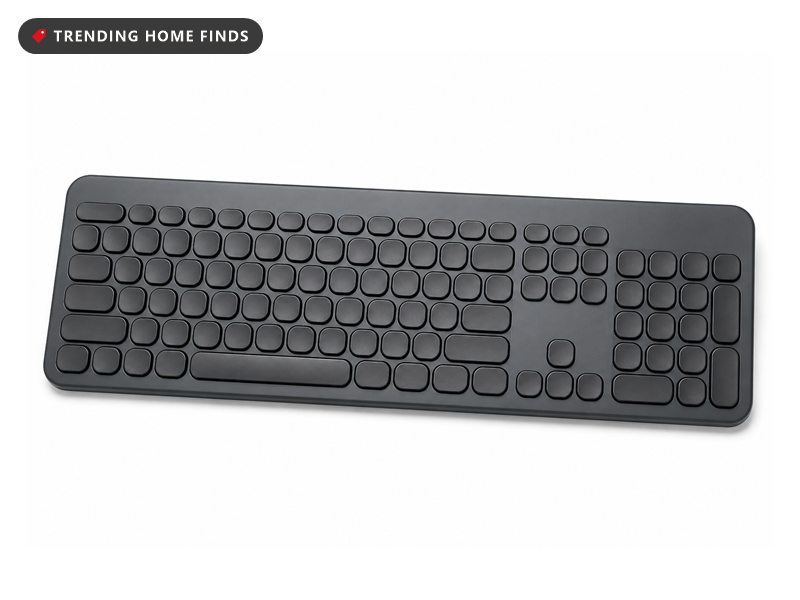 A graphite full size low profile keyboard with rounded rows of concave keys and a number pad.