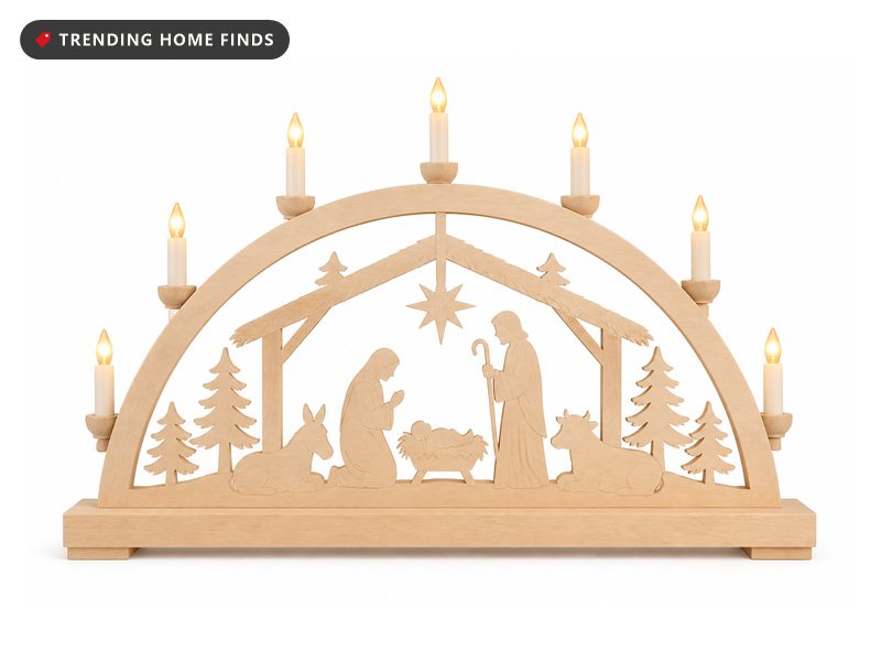 A lit wooden candle arch with a carved nativity, a stable roof and a star under LED candles.