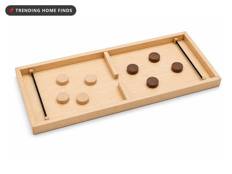 A wooden sling puck game board with a center gate, elastic bands at each end and round discs.